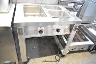 Servolift Eastern 501-2 stainless steel electric steam table with dual wells, commercial casters, and control knobs visible.