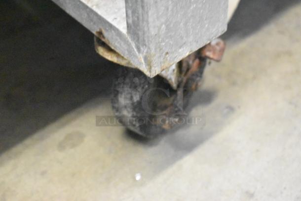 Servolift Eastern 501-2 stainless steel steam table caster, showing wear and surface rust, on commercial casters.