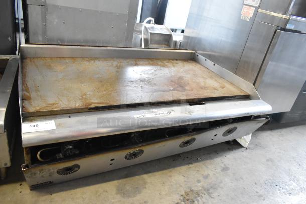 Stainless steel countertop propane gas griddle, commercial use, flat top, visibly used, two control knobs.