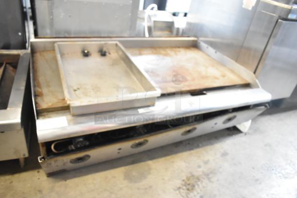 Stainless steel commercial countertop propane gas flat top griddle, used condition, visible burners, slightly worn surface.