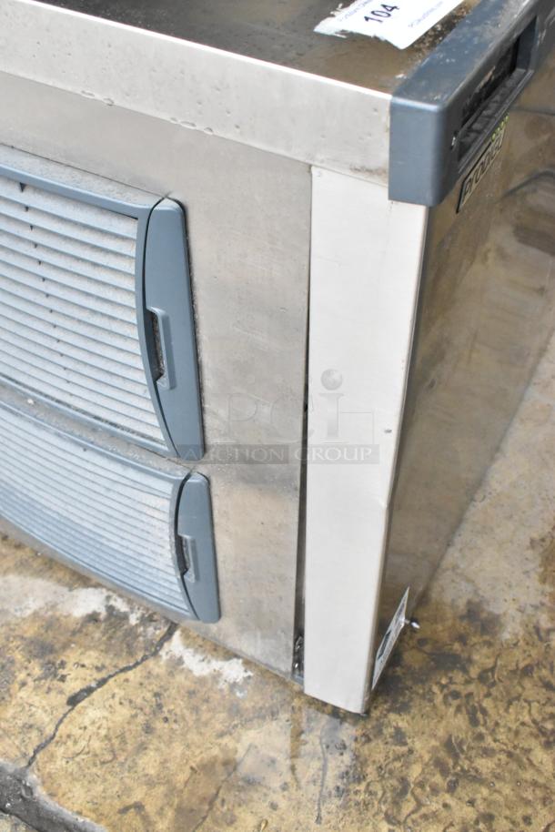 Scotsman C1030MA-32B ice machine, stainless steel, medium cube, 1077 lb capacity. Signs of wear visible. Model in view.