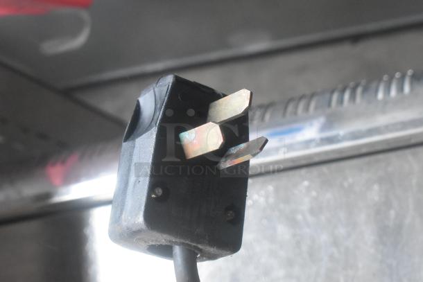 Close-up of a power plug for a Conti Club stainless steel commercial countertop espresso machine, in used condition.