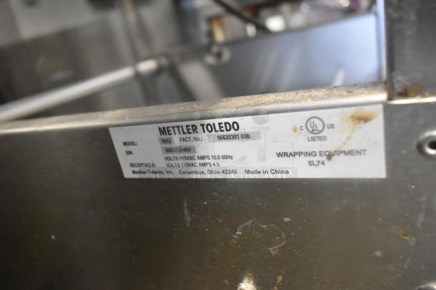 Mettler Toledo 0662 metal floor wrapping station with label showing model, voltage, and UL certification. Made in China.