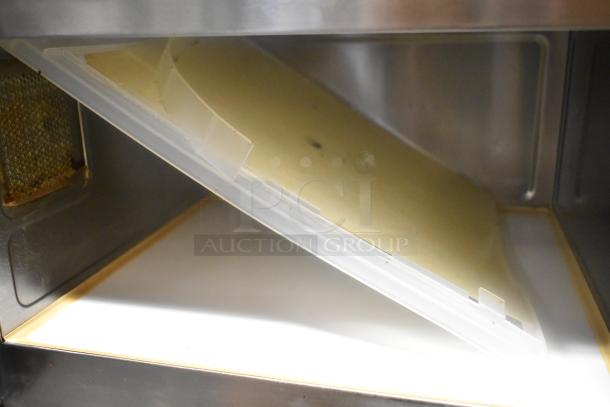 Interior view of Panasonic NE-1757R commercial microwave oven with clean, reflective surfaces and filter detail.