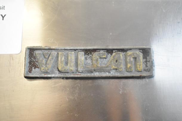 Vulcan commercial gas griddle, stainless steel, with 2 burners, oven, salamander cheese melter, visible Vulcan logo plate.