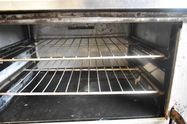 Vulcan stainless steel oven interior with two racks. Includes flat top griddle, two-burner range, and cheese melter. Worn condition.