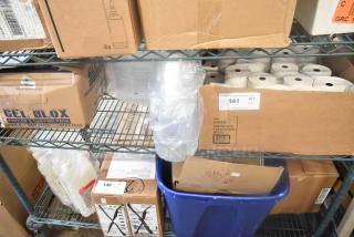 Boxes containing receipt printer rolls, sanitizer bottles, and other items on metal shelves. Auction lot labeled "141."