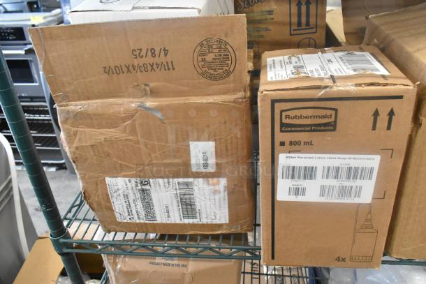 Boxes of various items on metal shelves, including Rubbermaid dispensers marked as 800ml hand soap. Boxes show shipping labels and slight wear.