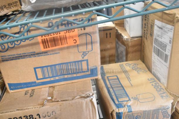 Cardboard boxes of various items including Scott brand foam skin cleanser, with visible barcodes and shipping labels.