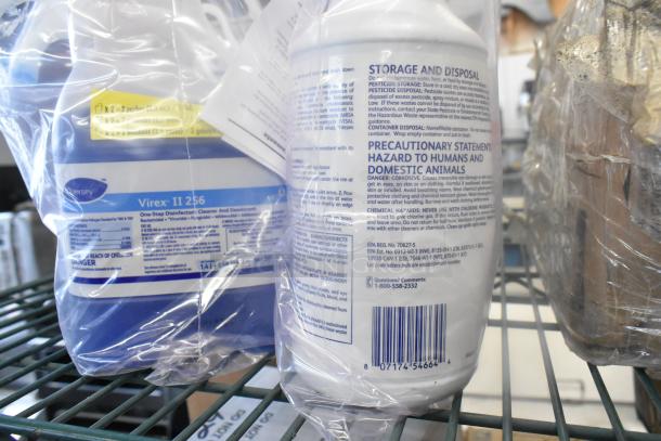 Assorted items including Virex II 256 disinfectant in protective plastic, featuring labeled storage and precautionary details.