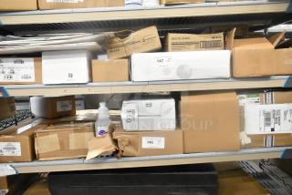 Shelf with diverse auction items including boxes of Diversey Sanitizer, Zebra Resin Ribbons, and Foresight Carrier Screen.