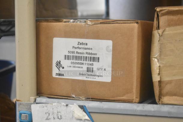 Box of Zebra Performance 5095 Resin Ribbons, 6 per box, label showing model and lot number details, shelf display.