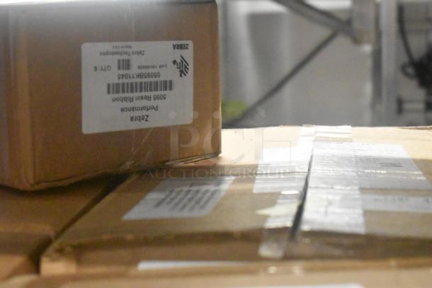 Close-up of stacked boxes of Zebra 5095 Resin Ribbon, labeled with product details, in good condition for auction.