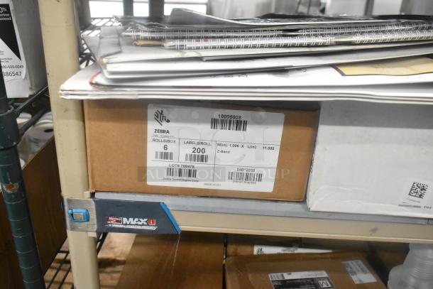 Box labeled "Zebra Labels," 6 rolls, 200 labels/roll, on shelf with other items. Ideal for label printing use.
