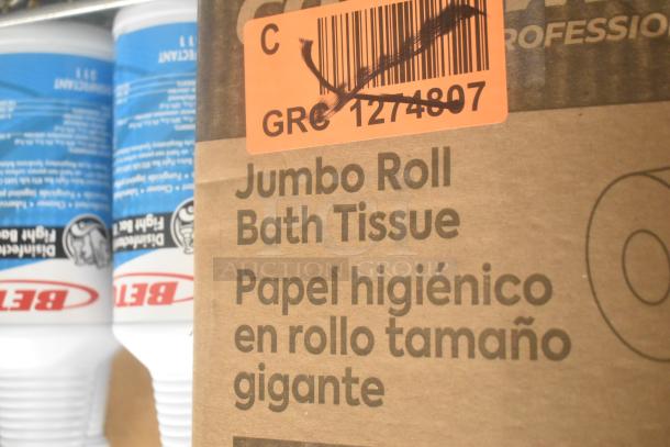 Betco disinfectant bottles, jumbo bath tissue roll box labeled in English and Spanish, auction barcode tag visible.