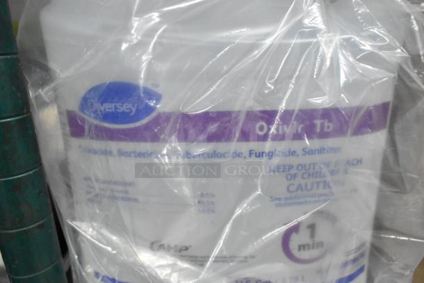 Diversey Oxivir Tb sanitizer pack with visible label details, part of a 12-item lot including hand soap and cleansers.