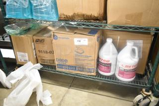 Boxes of Dixie Ultra napkins, Purell wipes, Aunt Flow tampon cartridges on metal shelf, Betco cleansers visible. Auction item 158.