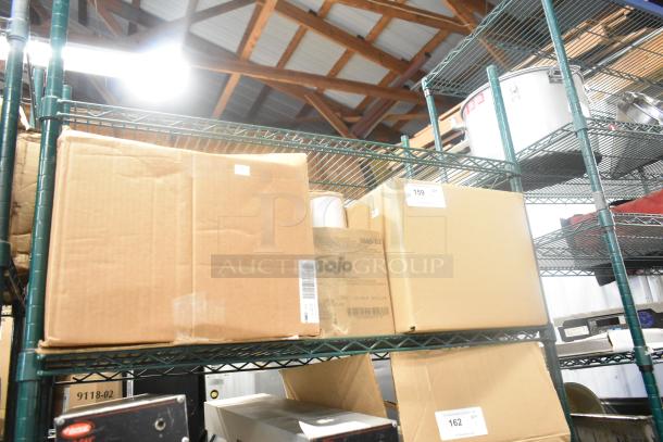 Cardboard boxes on shelves, including a Gojo Hand Cleaner box. Labels with lot numbers visible. Auction item: bid for four items.
