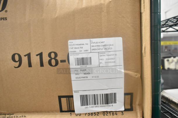 Cardboard box labeled with Gojo Industries address and part number 9118-02. Shipping label visible, indicating destination.