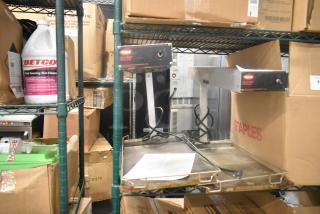 Hatco Metal Commercial Countertop Warming Station, 120 Volts, 1 Phase, on a storage rack. Features include metal exterior, visible wiring, and attached control panel. Appears in used condition.