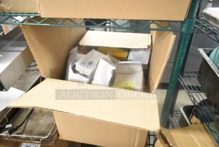 Box of assorted items including Cardinal index cards, open box, various packages visible, stored on metal shelving unit.