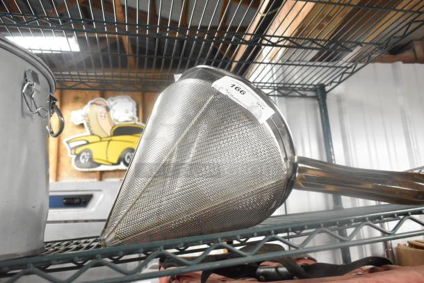 2 metal china cap strainers on a wire shelf, stainless steel mesh, sturdy handles, auction tag labeled "166".