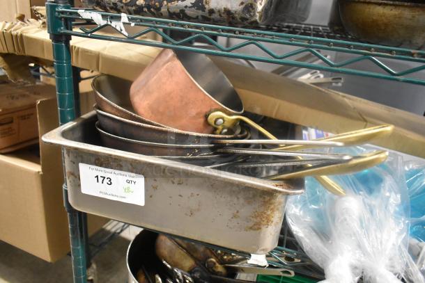 Eight metal kitchen items including skillets and a drop-in bin, visible wear, lot number 173, PCI Auctions tag.