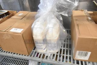 Seven items including boxes and plastic-wrapped bottles on a metal shelf. Box labeled with "179," possible inventory or lot number.