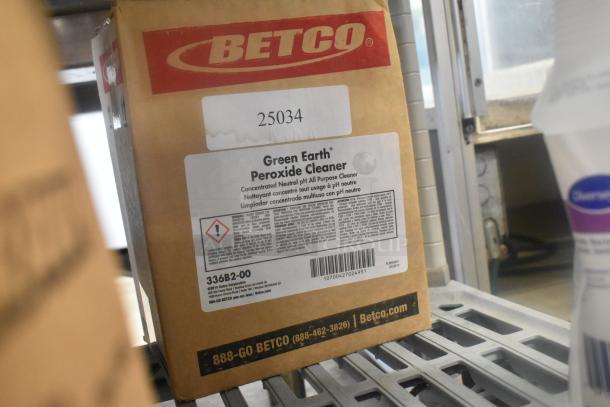 Box of Betco Green Earth Peroxide Cleaner on a shelf, labeled as a concentrated neutral pH all-purpose cleaner.