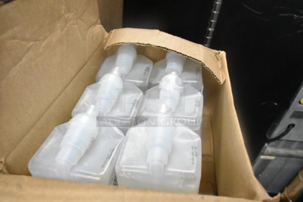 Cardboard box with multiple sealed plastic containers, likely replacements for dispensers, with visible expiration dates.