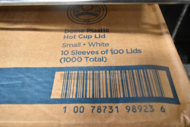 Box of 1000 small white dome plastic hot cup lids, 10 sleeves of 100 each. Barcode and product details visible.