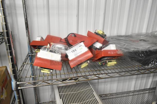 Ten red fire alarm lights on a metal shelf, includes wiring and components. Tags show quantity and auction details.