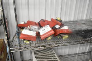 Ten red fire alarm lights on a metal shelf, includes wiring and components. Tags show quantity and auction details.