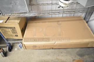 Cardboard box marked "Globe 6000018" on shelf, contents include a diaper changing station. Box shows wear, handle with care.