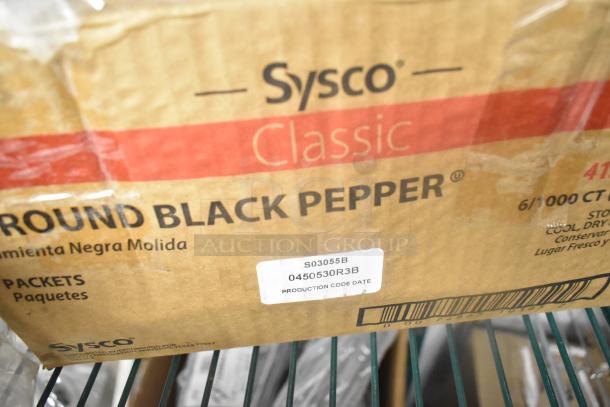 Box of Sysco Classic Ground Black Pepper, labeled with production code S03055B, in cardboard packaging on a shelf.