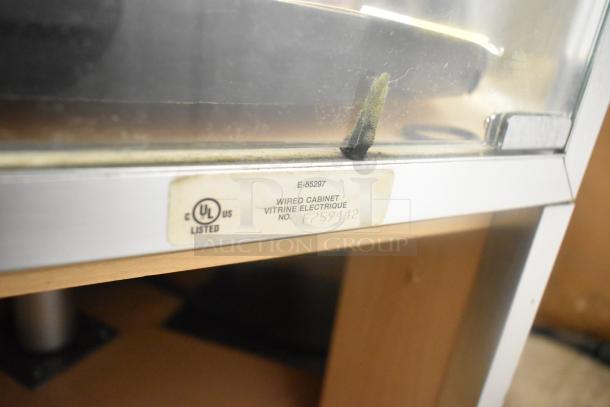 Merchandiser display case with glass panel and metal frame. UL listed label: Wired Cabinet, Vitrine Electrique No. F759842.