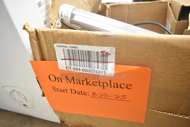 Cardboard box with visible wear, contains a metal cylinder. Barcode label marked "Control Tower, CT-244-000034411". Orange tag reads "On Marketplace, Start Date: 8-25-25".