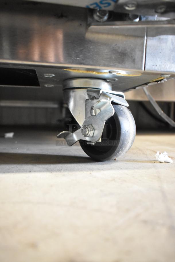 Commercial caster wheel of a 2020 Traulsen UPT6024-LR stainless steel prep table, showing sturdy construction and lock mechanism.