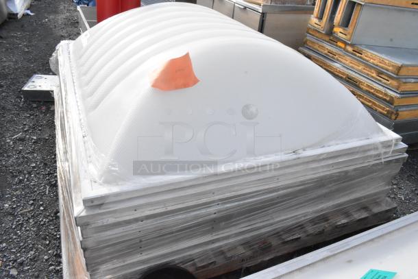 Stack of five dome covers in white, made from durable material, wrapped in plastic on a pallet. Ideal for architecture.