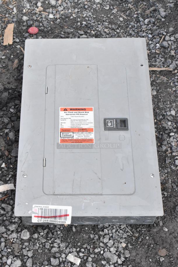 Gray metal electrical box with warning label about arc flash risk. Labeled "Brown and Caldwell." Barcode "CT-244-000034569."