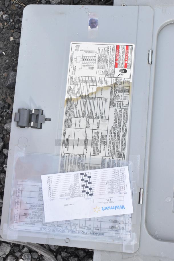 Gray metal electrical box with circuit label chart and safety warning stickers. Slight wear, visible surface markings.