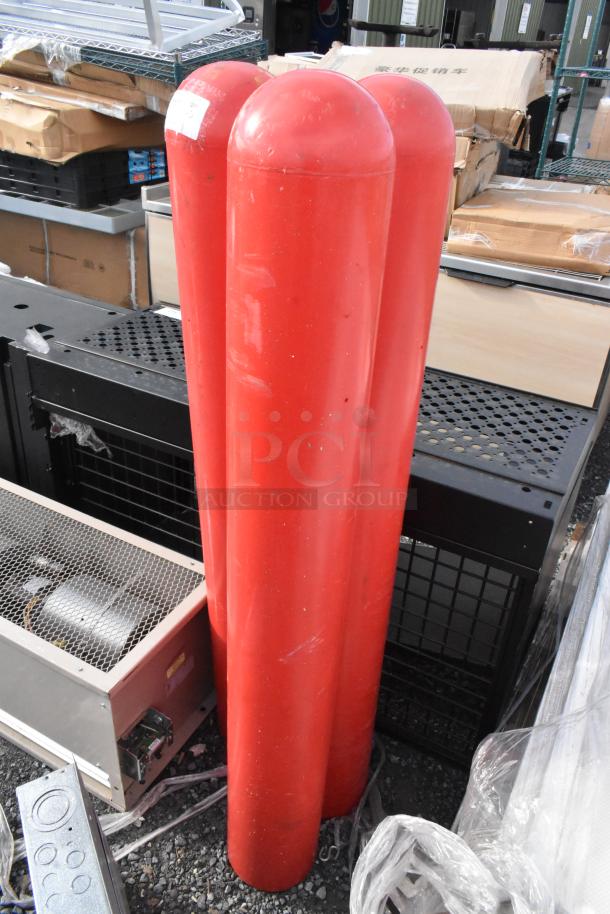 Three red column bumpers for sale, in good condition, tall cylindrical shape, ideal for protection or decoration.