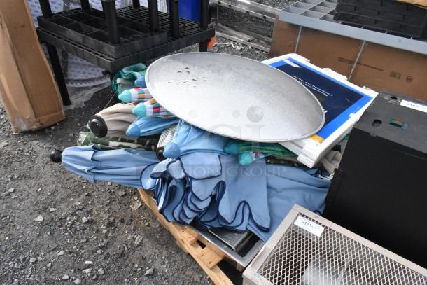 Pallet with assorted items including multiple closed umbrellas, a large round metal tray, and miscellaneous boxes in used condition.