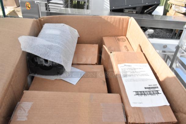 Box containing various brand new items, including Nexa Hand Hygiene Dispenser, wrapped in protective material.