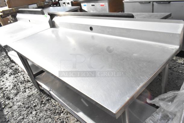 Win-holt stainless steel table with under shelf and backsplash, in good condition. Features embossed logo and durable finish.