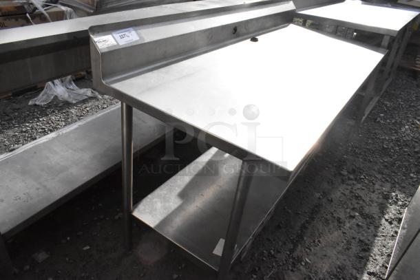 Win-holt stainless steel table with under shelf and back splash. Features durable construction, suitable for kitchens.