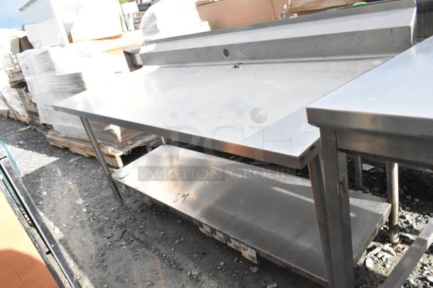 Win-holt stainless steel table with under shelf and back splash, used condition, sturdy construction, ideal for commercial kitchens.
