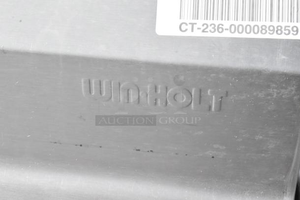 Win-holt stainless steel table with under shelf and back splash, featuring durable construction. Embossed logo visible.