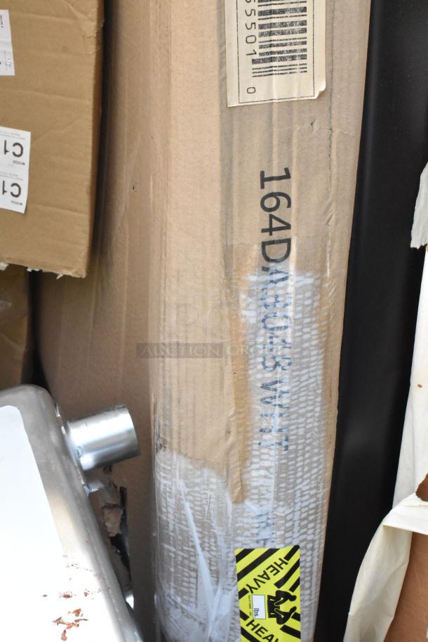 Boxed scratch and dent items including a hood filter and table. Visible labels indicate item codes and a "Heavy" sticker.