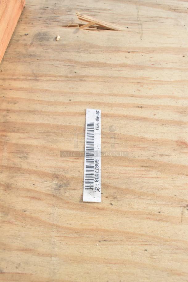 Barcode tag with number 6687008 on wooden surface, indicating a brand new scratch and dent item.